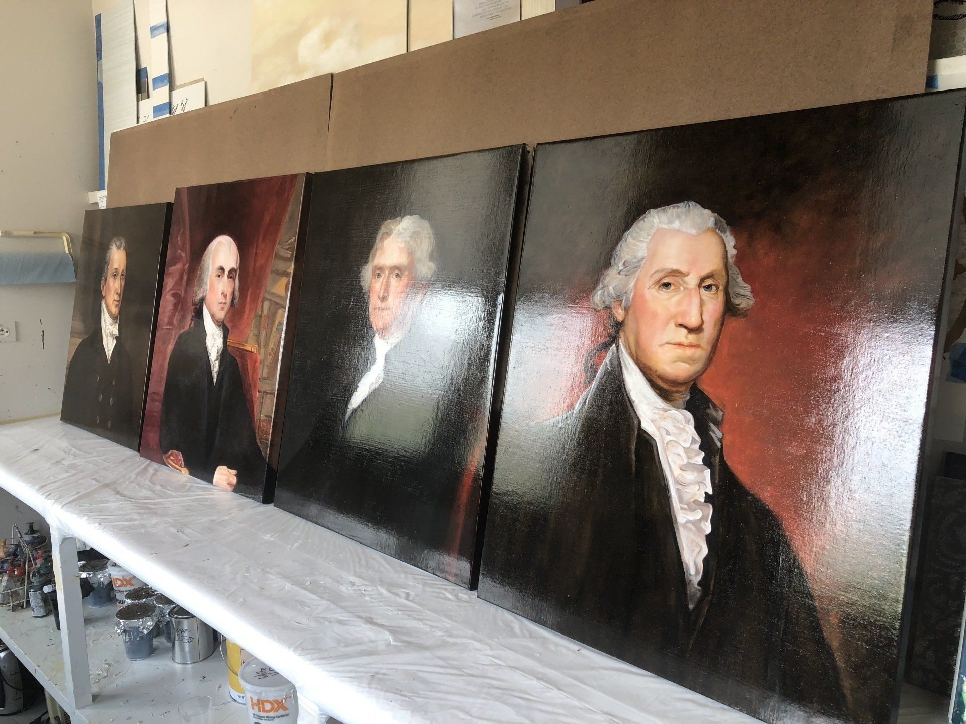 Four paintings of george washington are sitting on a table