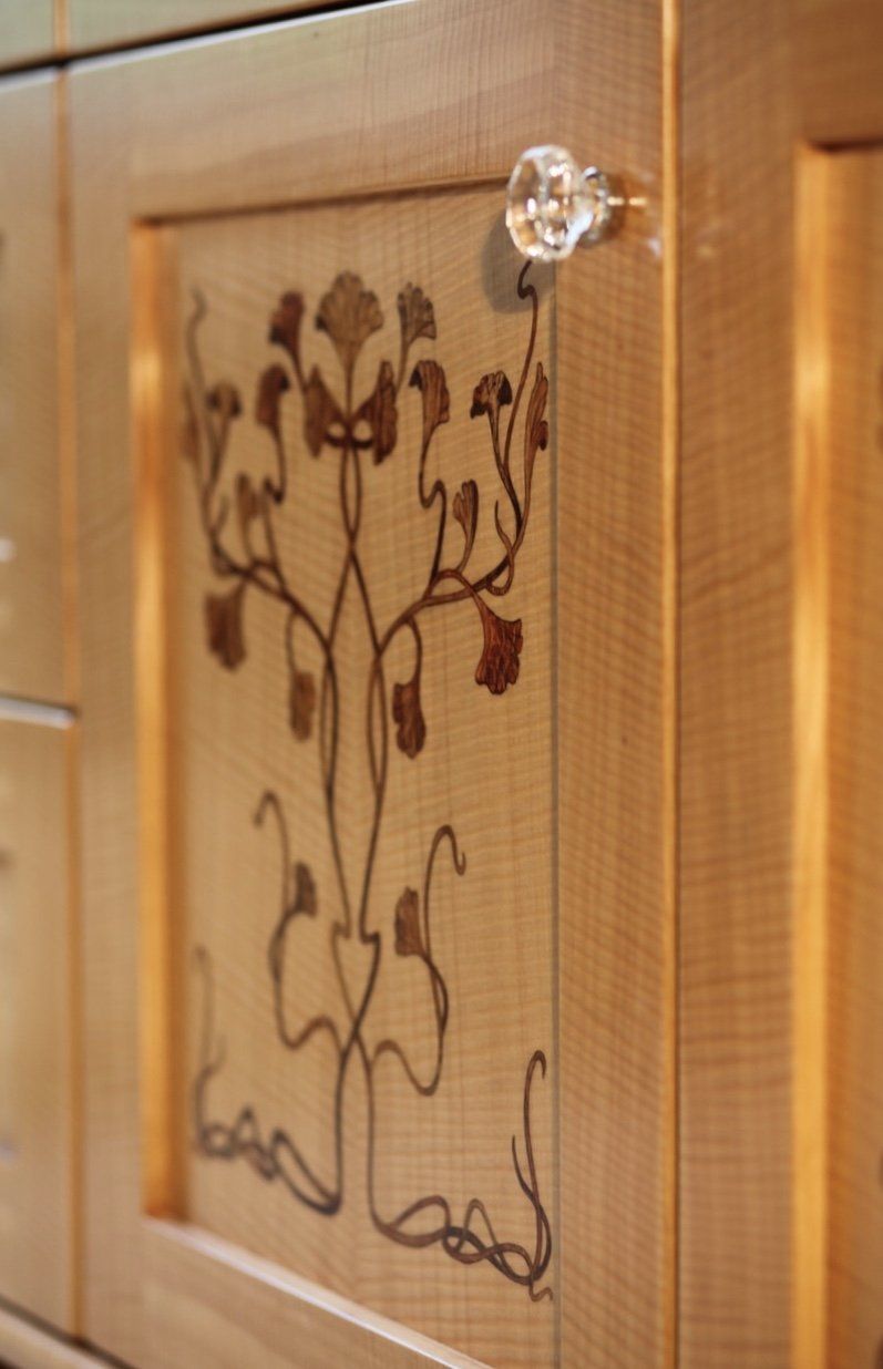 A wooden cabinet with a tree design on it