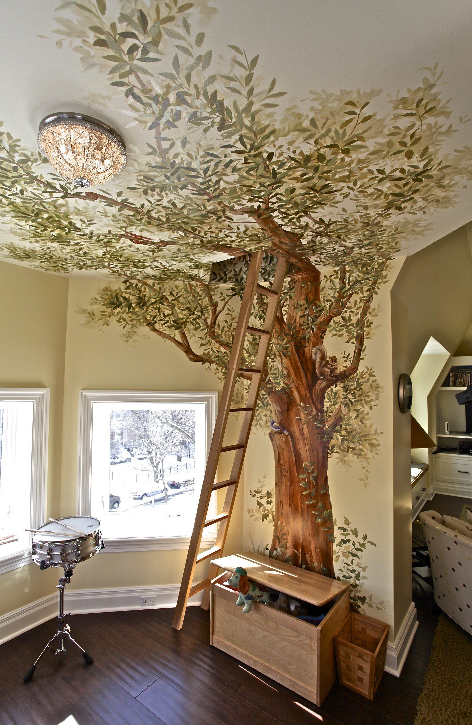 A room with a tree on the wall and a ladder leading up to it.