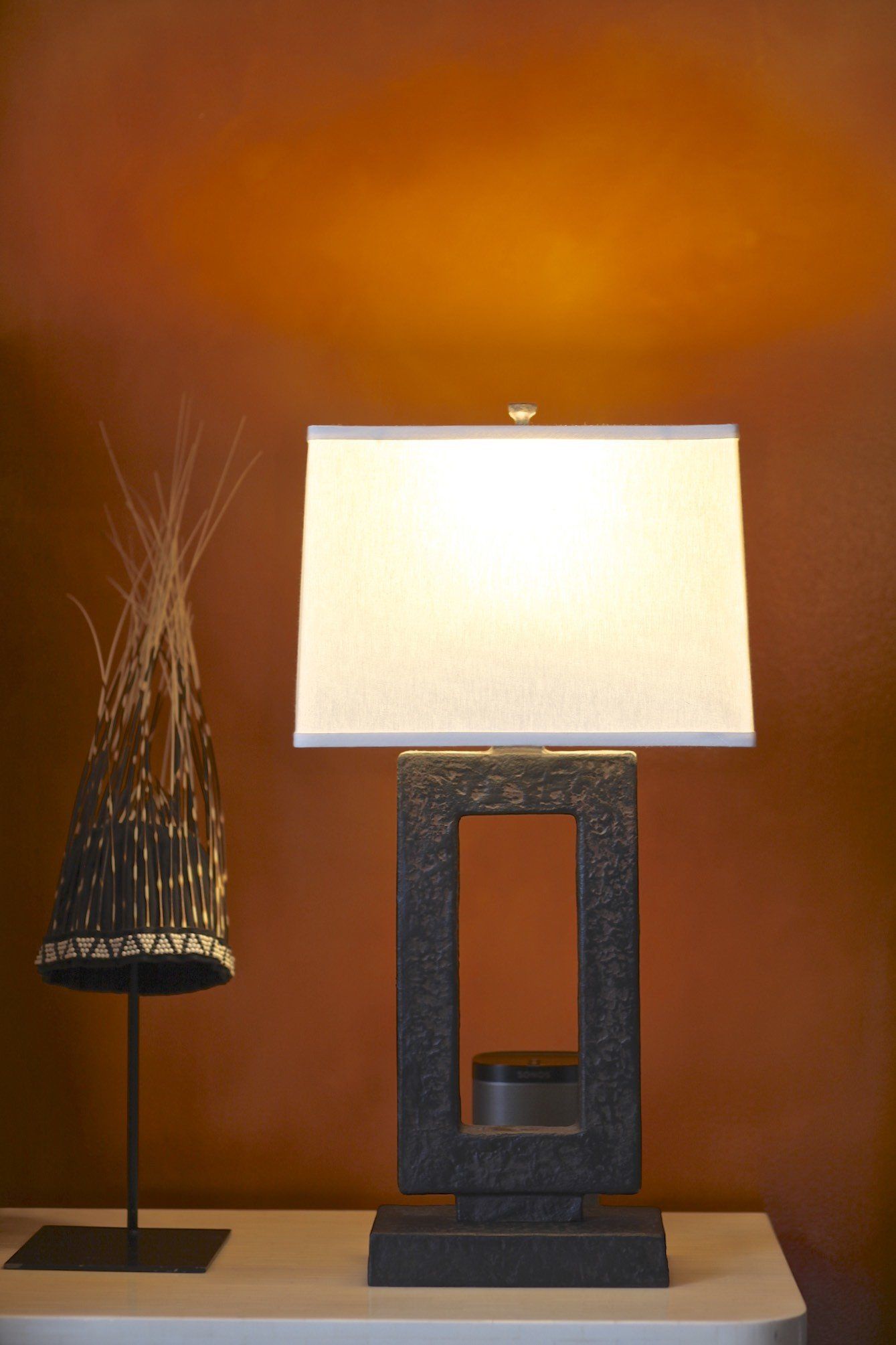 A lamp is sitting on a table next to a statue