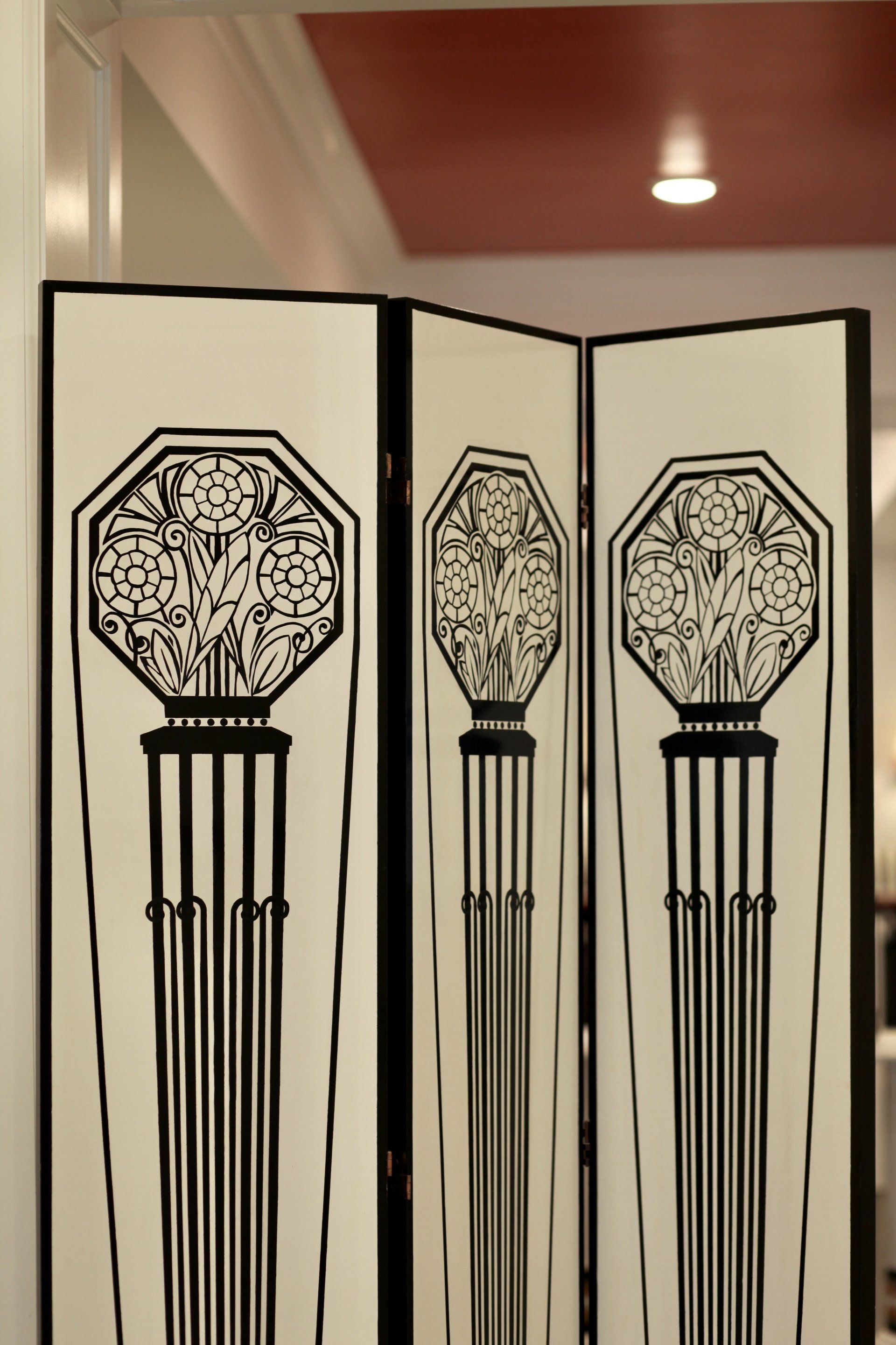 A black and white room divider with a floral design on it