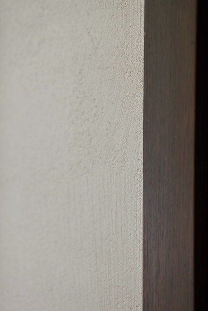 A close up of a white wall with a black corner.