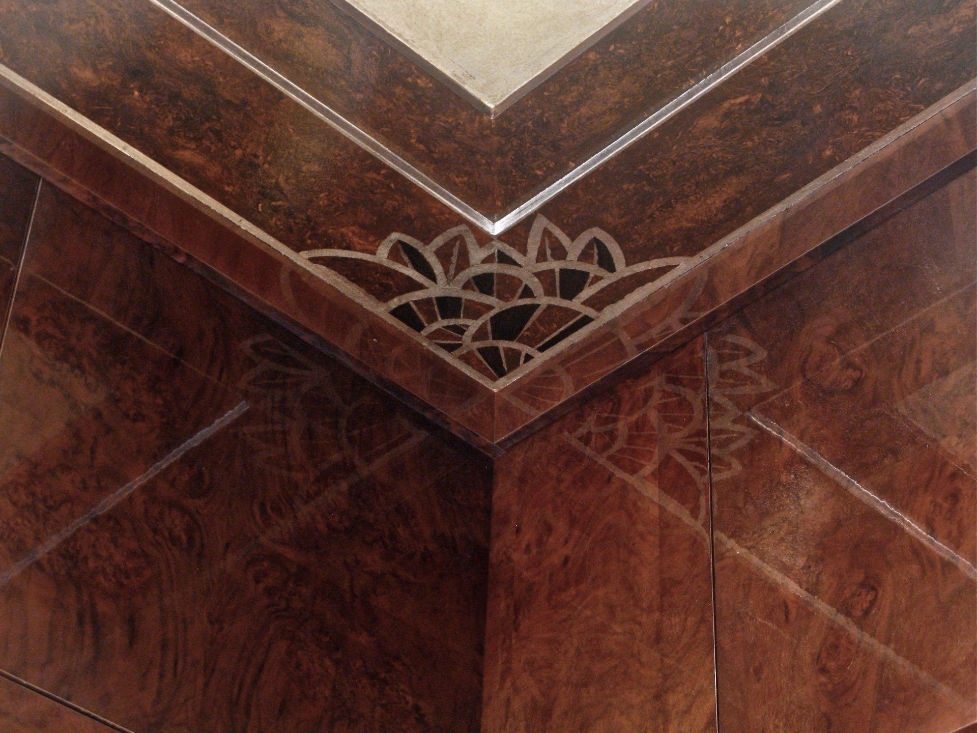 A close up of a wooden corner with a design on it