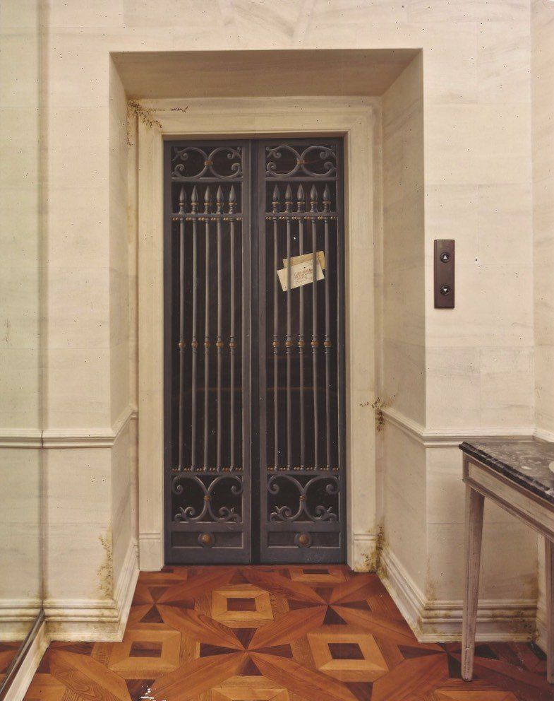 A closed elevator door with a piece of paper taped to it