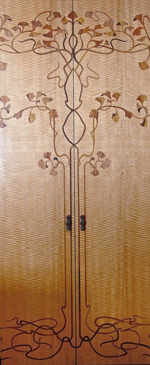 A close up of a wooden door with a tree design on it.