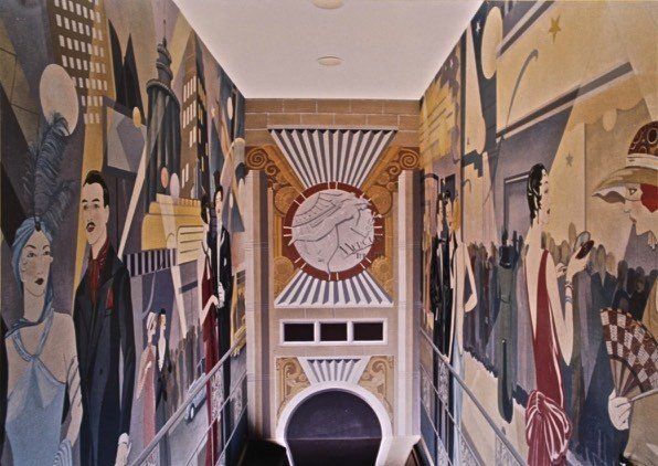 A staircase with a large mural on the wall