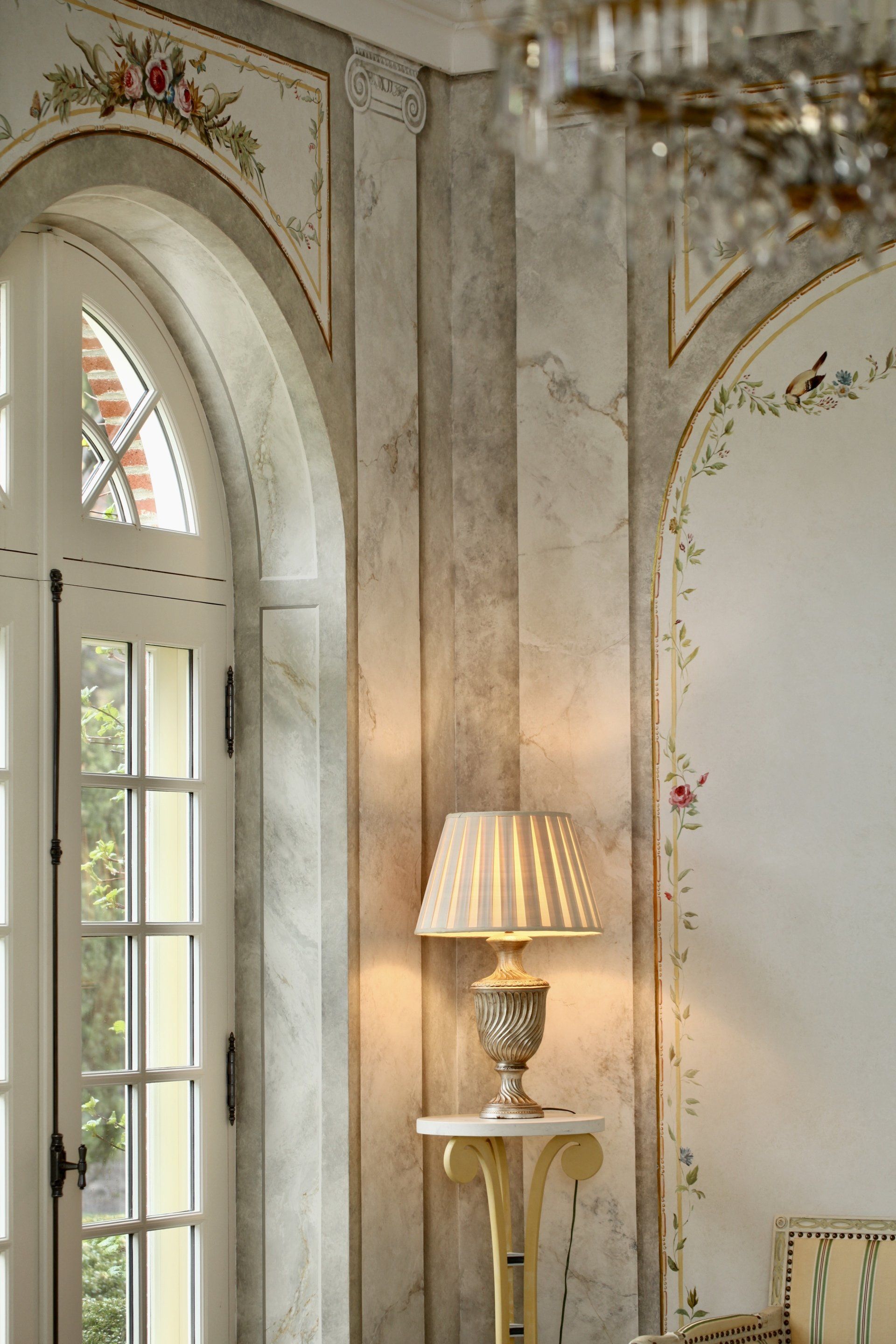 A lamp is sitting on a table in a room next to a window