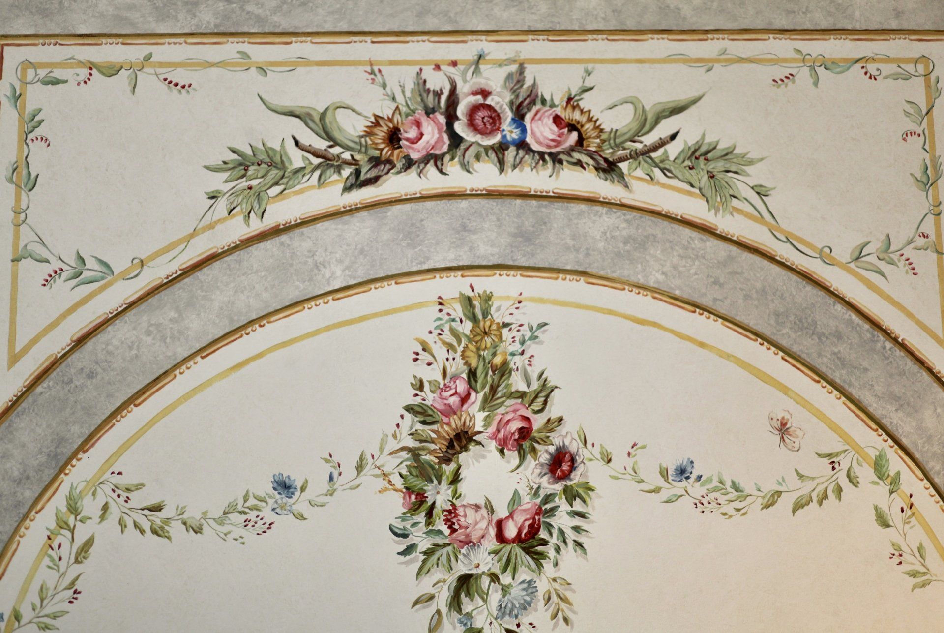 A painting of flowers and leaves on a wall
