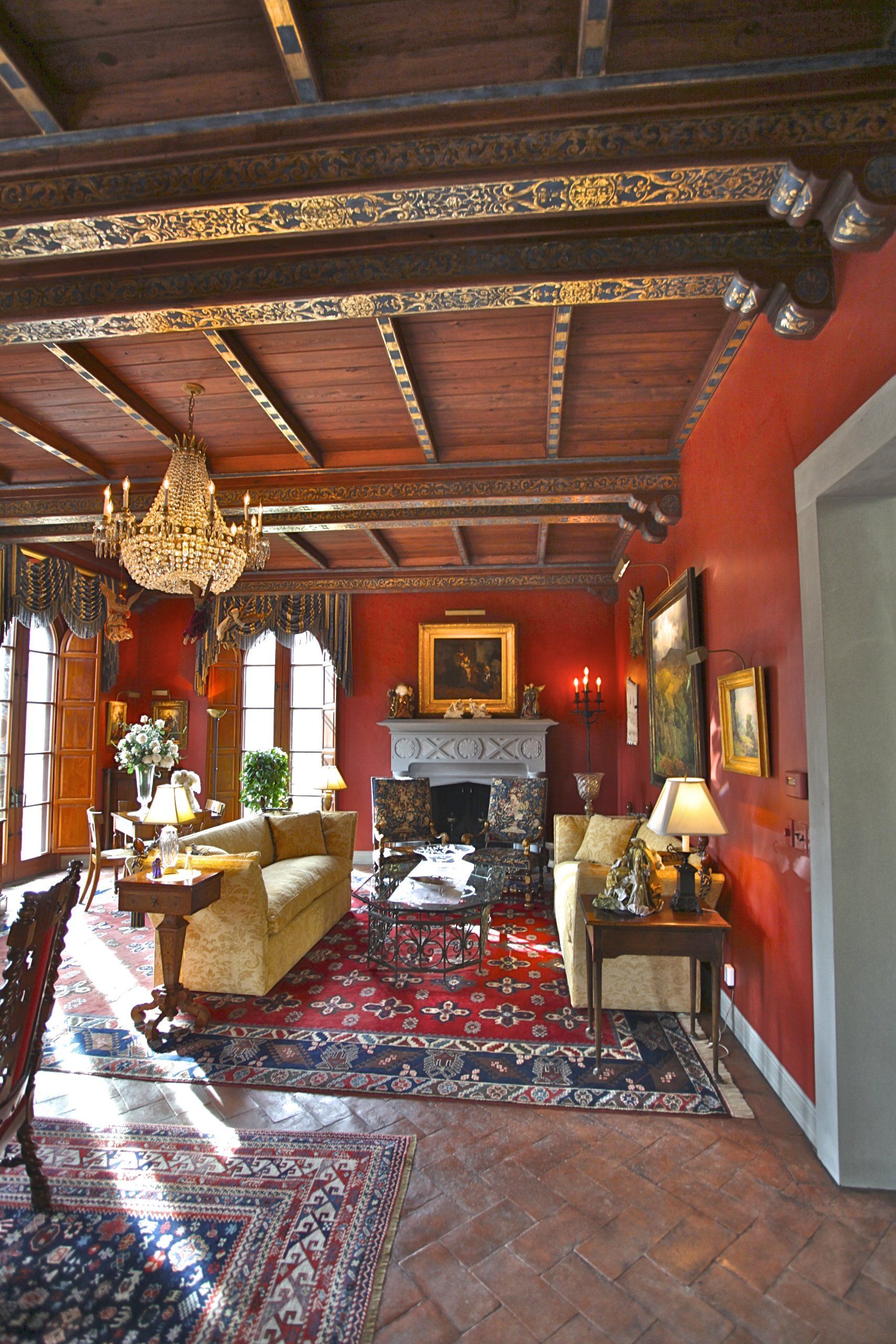 A living room with red walls and a fireplace