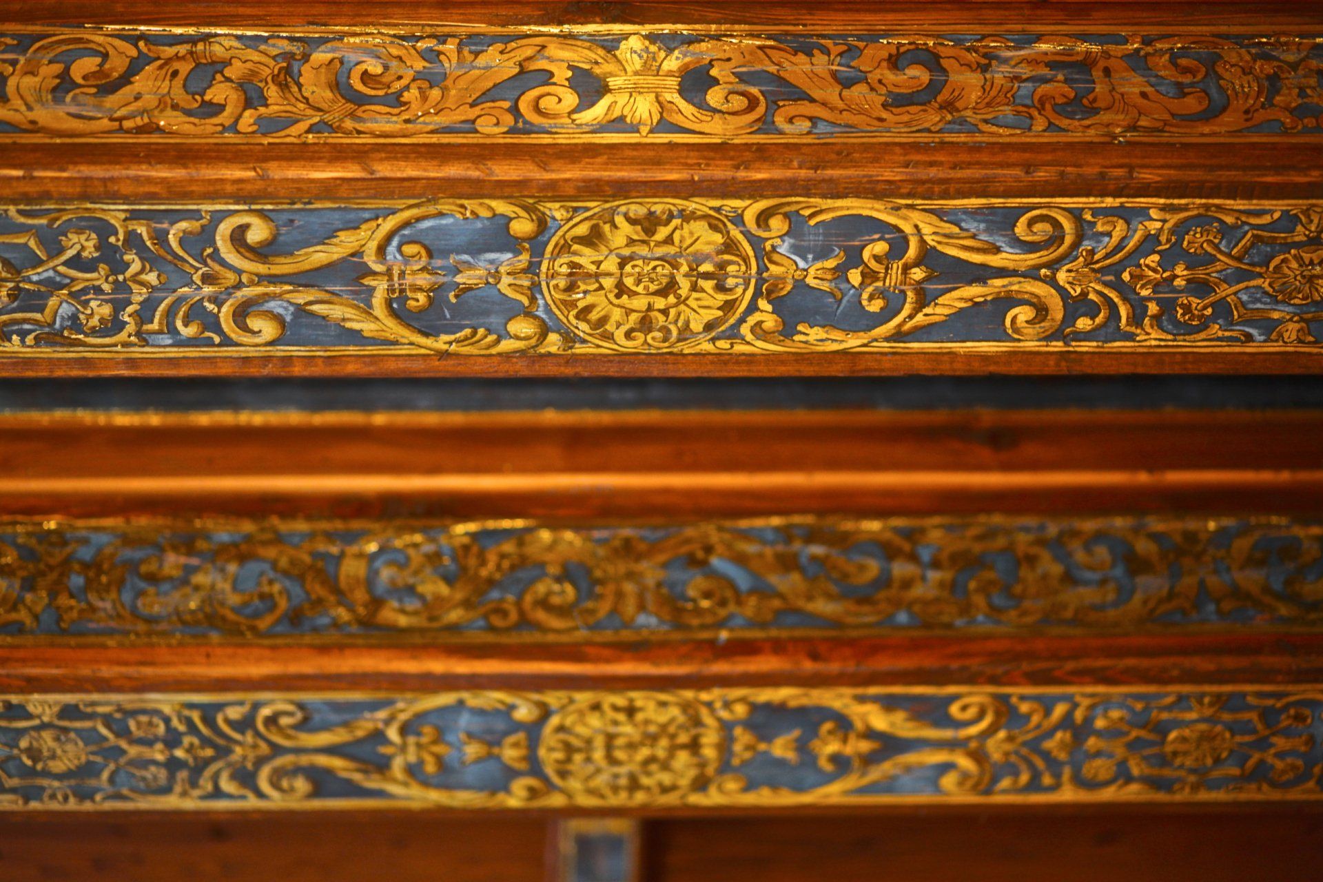 A close up of a wooden table with a blue and gold design on it.