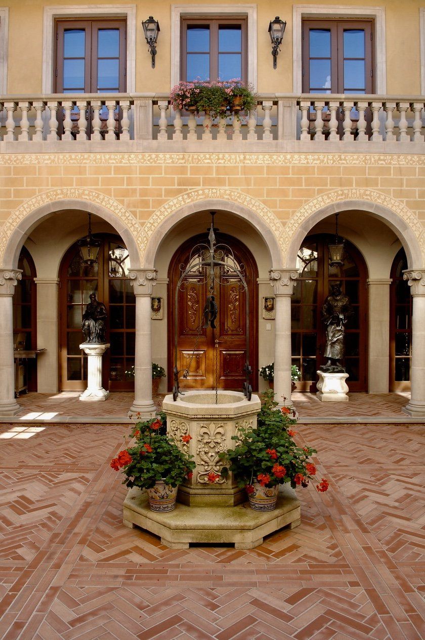 A courtyard with a fountain and flowers in front of a building