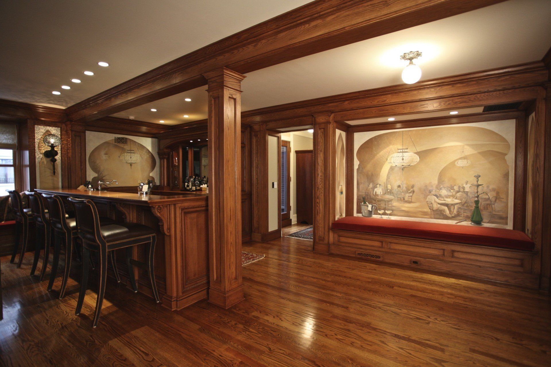 A large room with a bar and a painting on the wall.