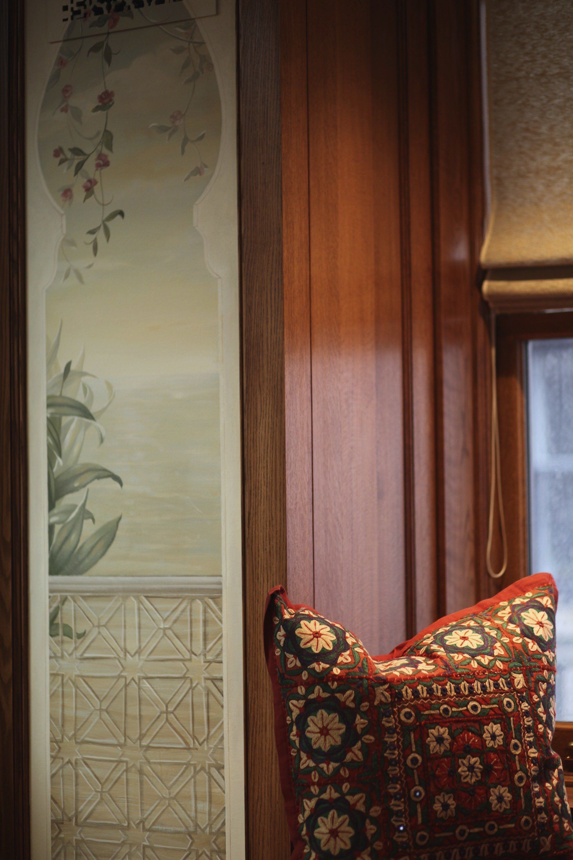 A pillow is sitting on a chair in front of a window.