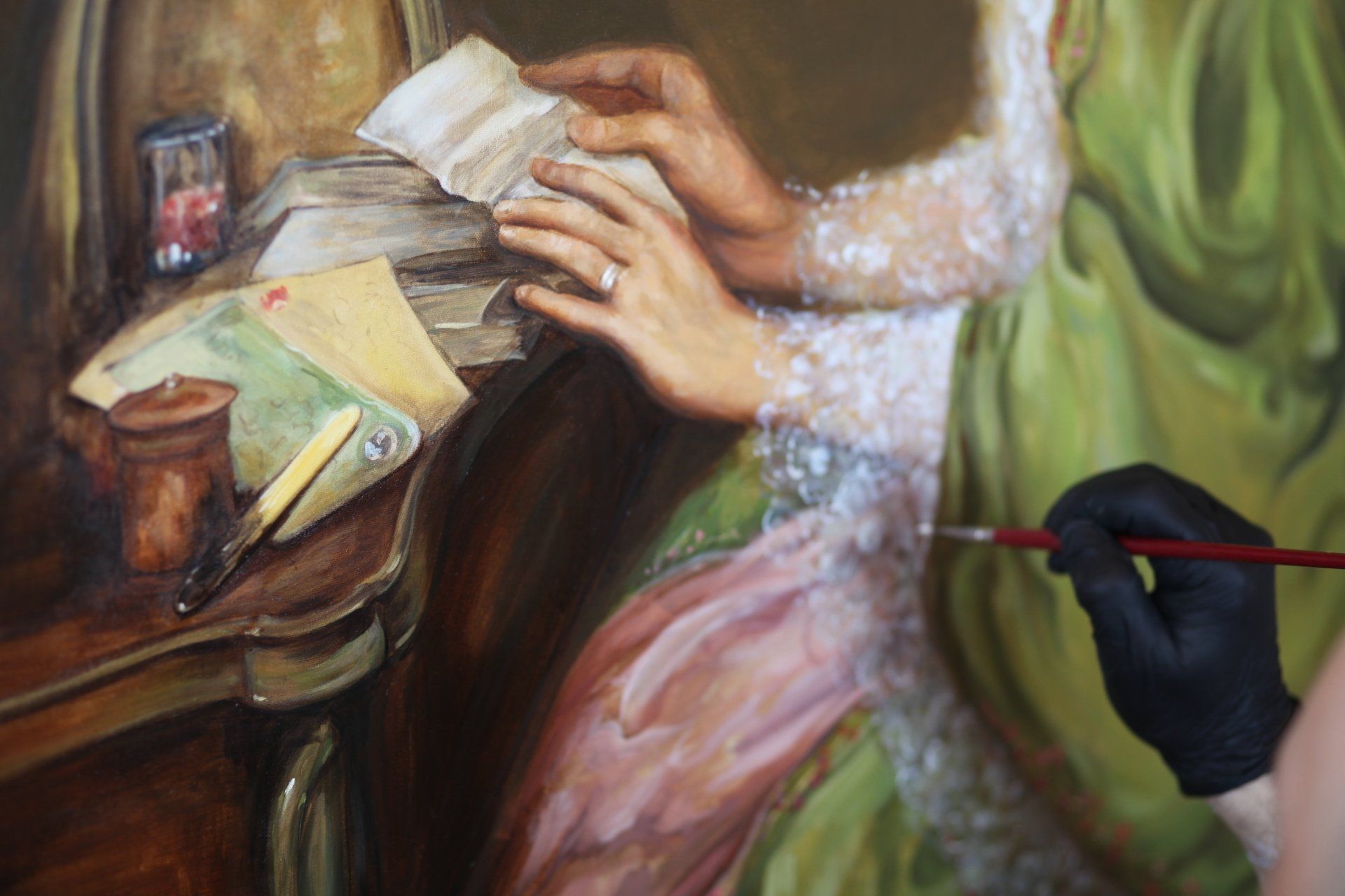 A person is painting a portrait of a woman sitting at a table.