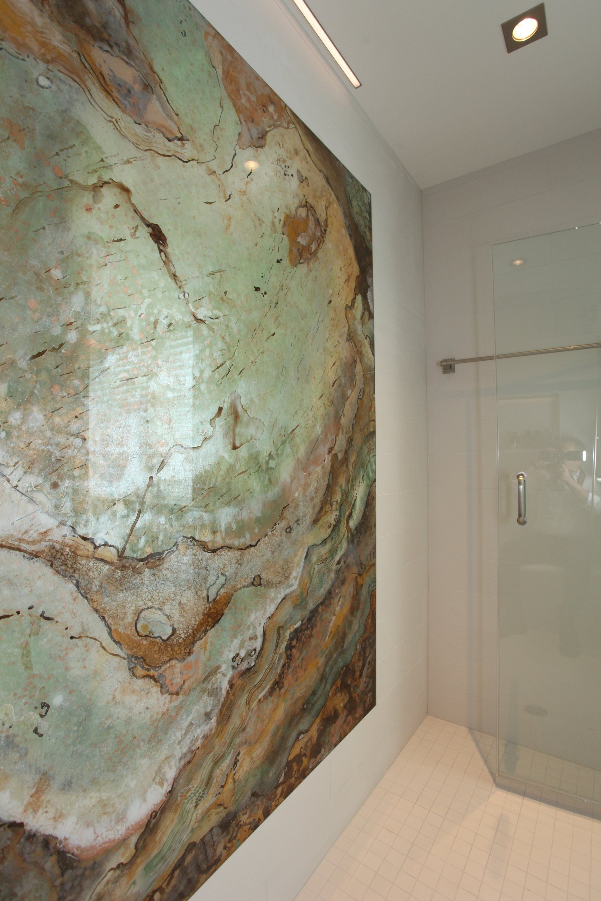 A bathroom with a large painting on the wall and a walk in shower.
