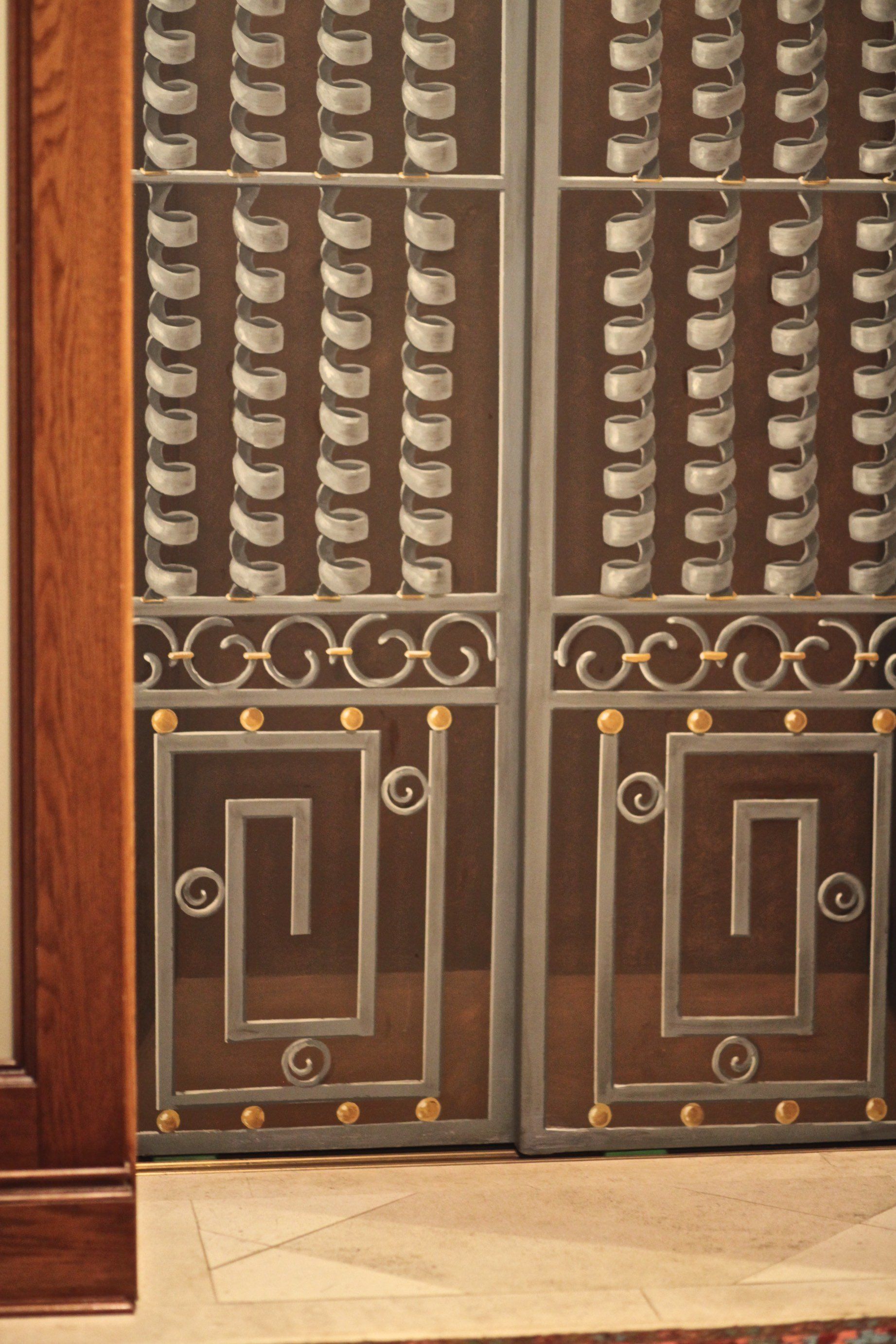 A wrought iron door with a greek key design on it
