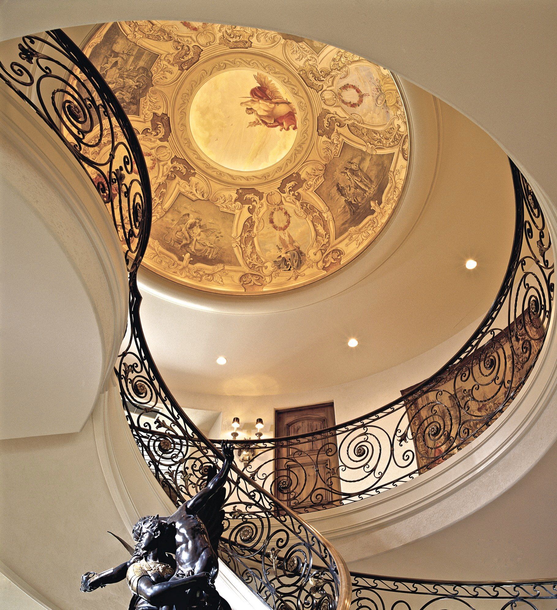 Looking up at a spiral staircase with a dome ceiling