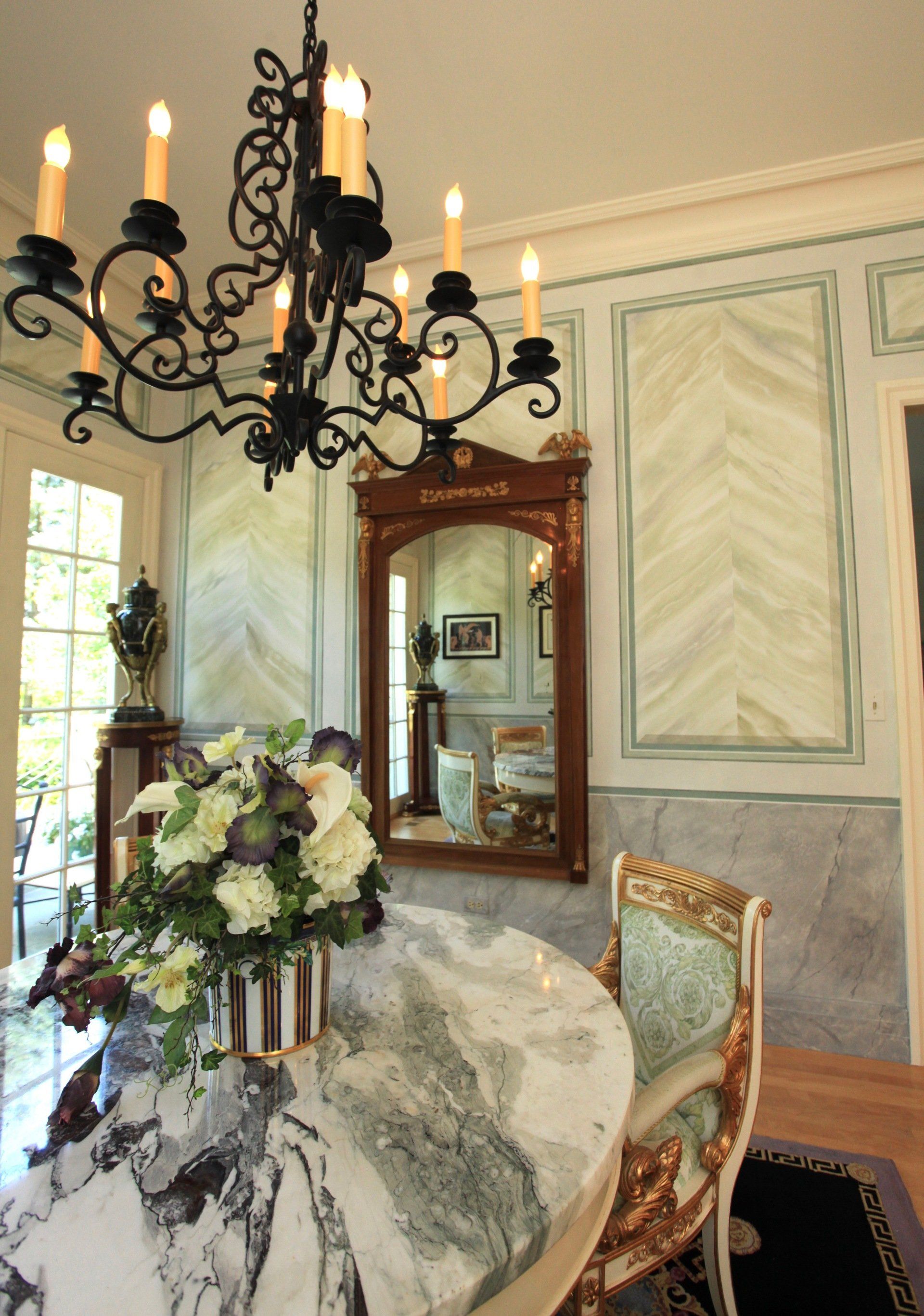 A dining room with a table and chairs and a chandelier