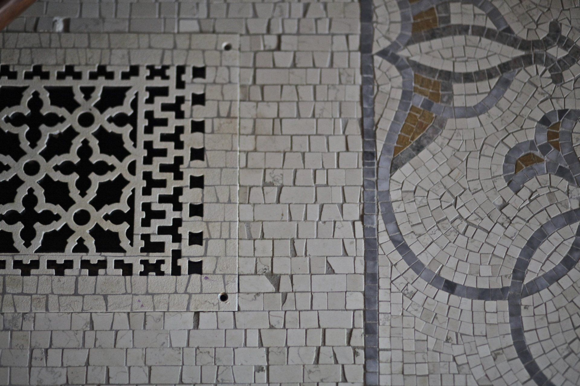 A brick wall with a mosaic pattern on it