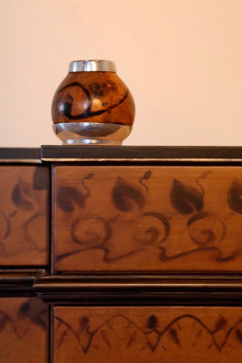 A vase is sitting on top of a wooden dresser