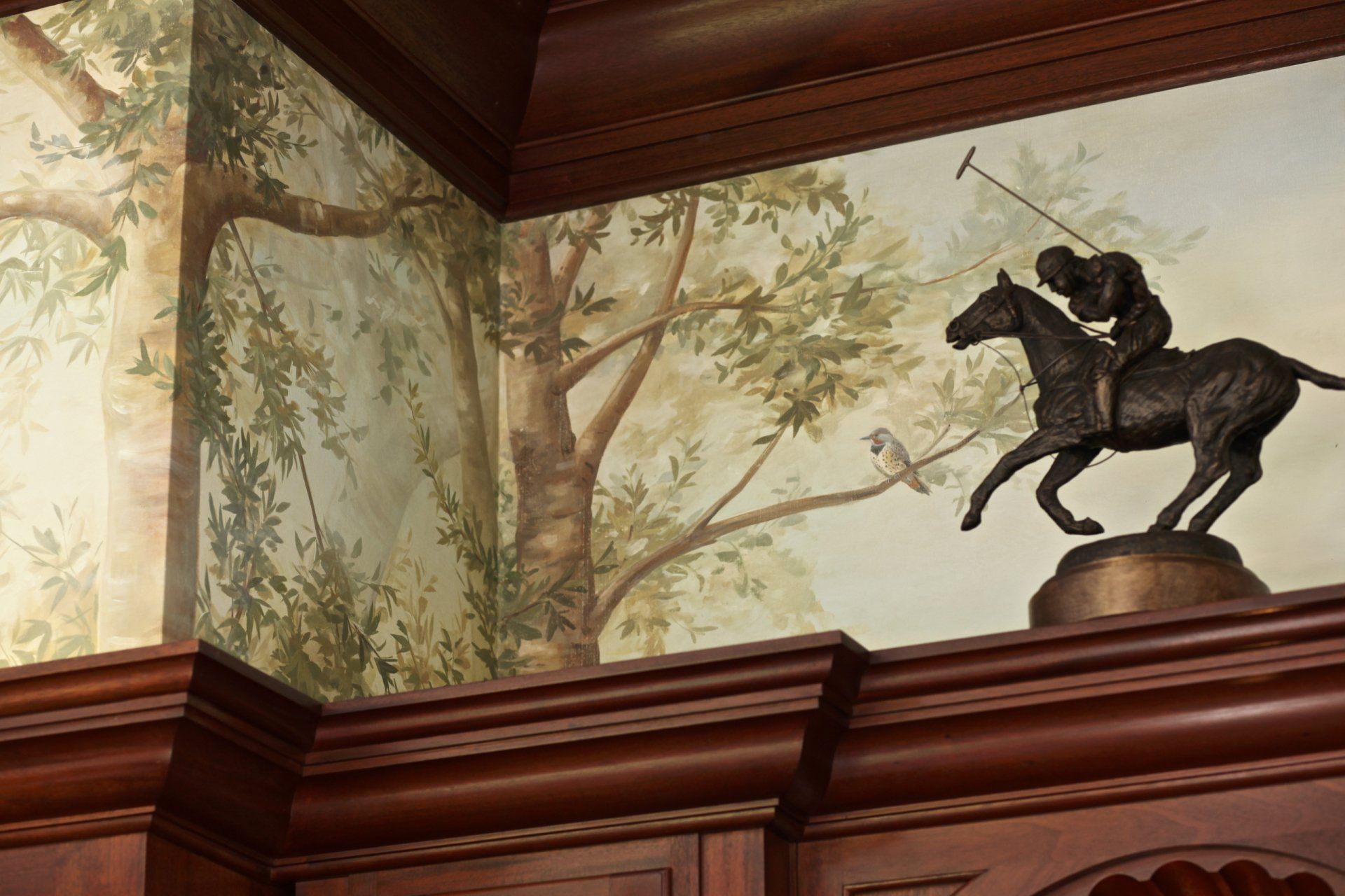 A statue of a man riding a horse with trees in the background