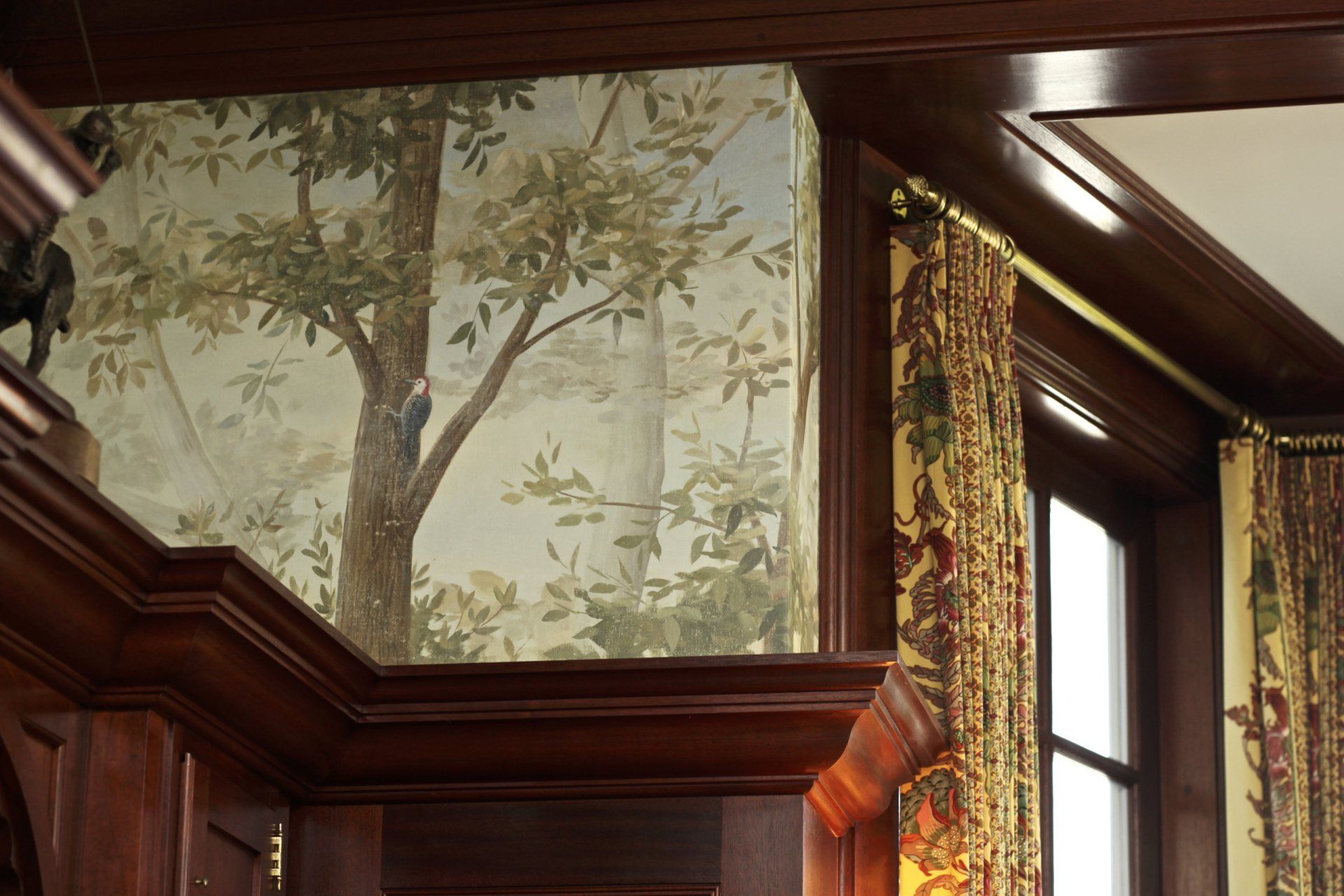 A room with a painting of trees on the wall