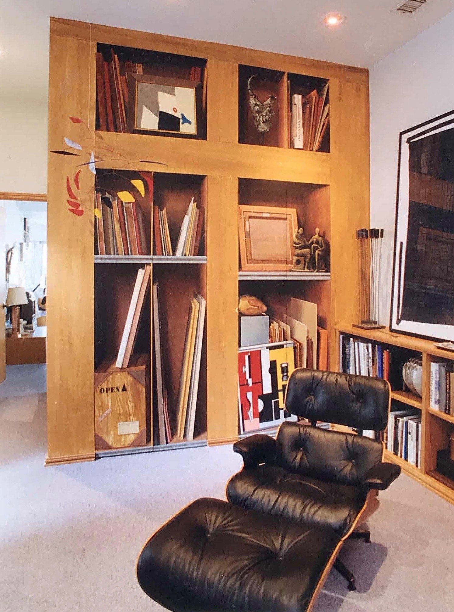A chair and ottoman in front of a wall of bookshelves
