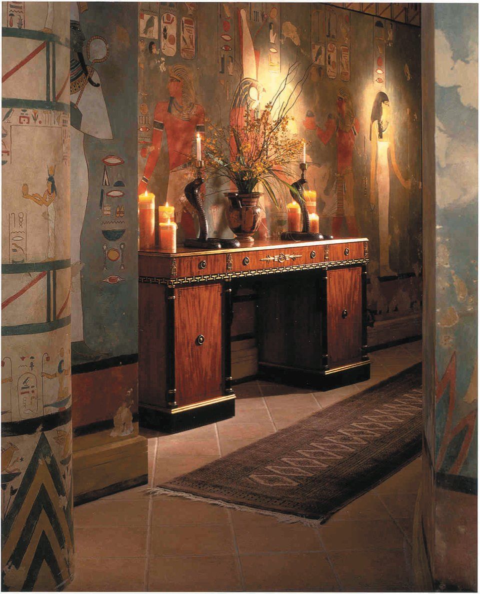 A hallway with a painting on the wall and a table with candles on it