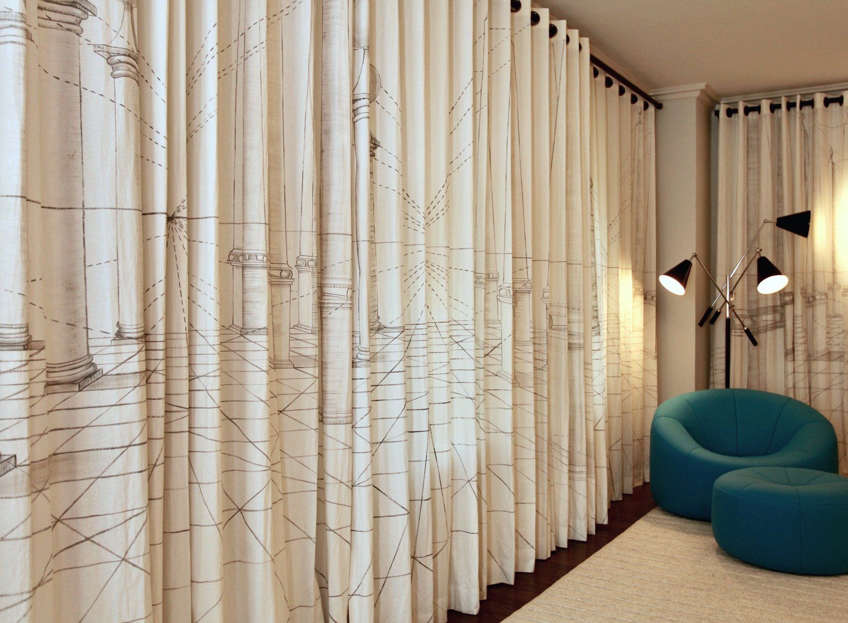 A blue chair sits in front of a wall of curtains