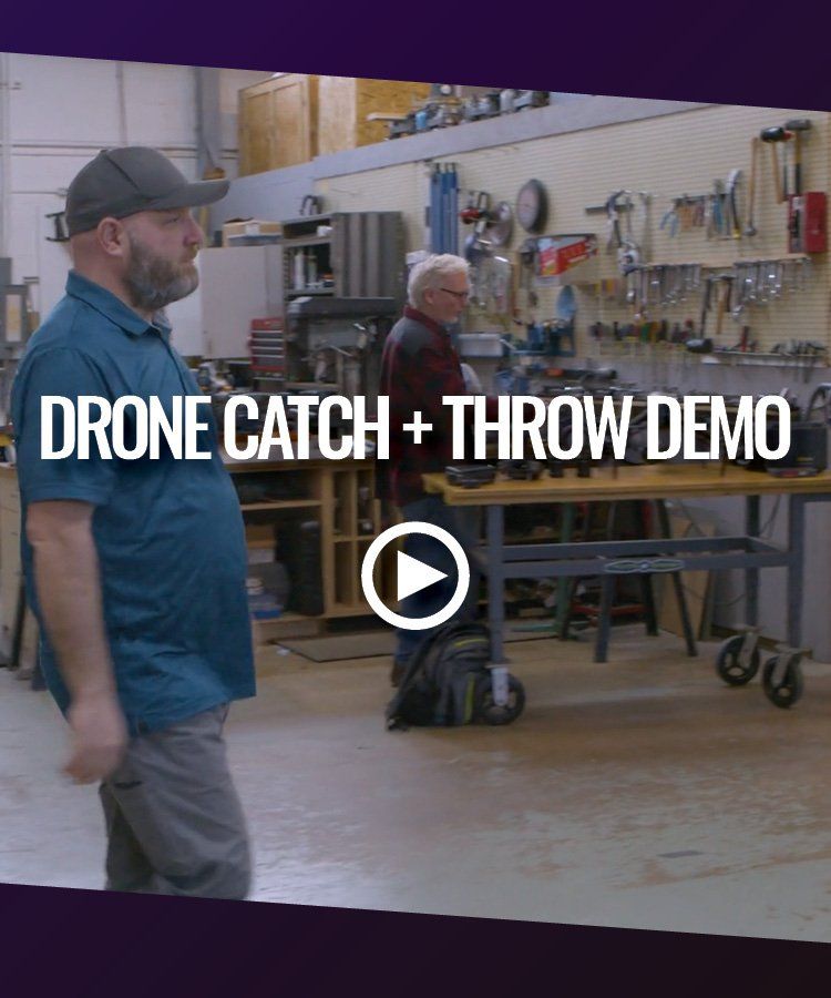 A man is standing in a workshop with the words drone catch and throw demo on the bottom