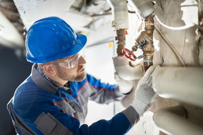 Male Worker Inspecting Valve — Allentown, PA — Fred J Moyer Plumbing Inc