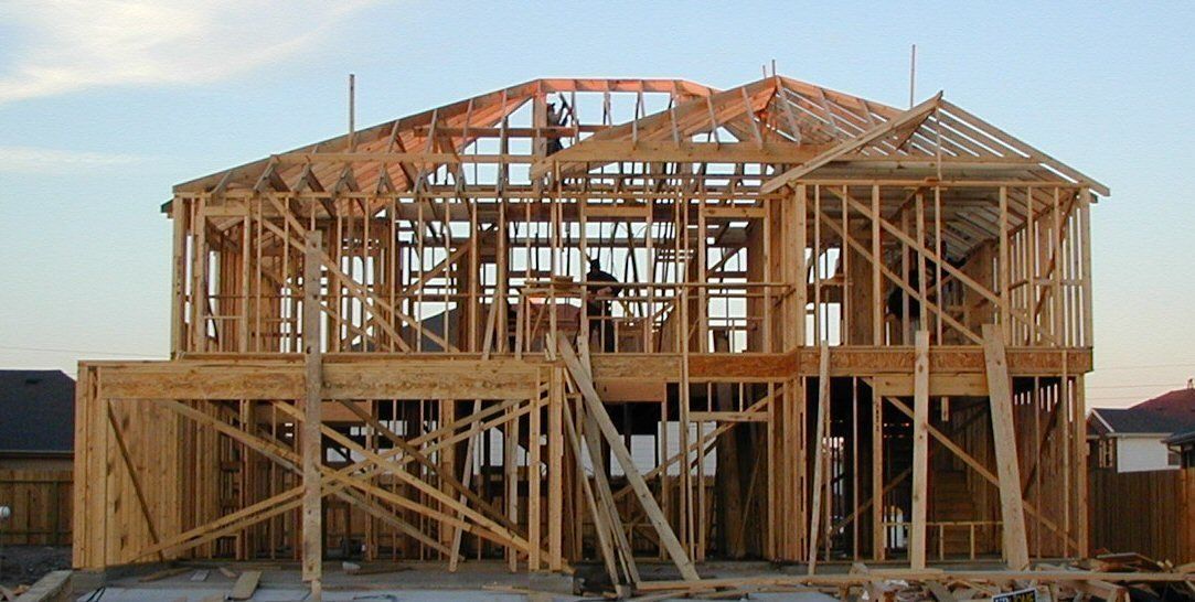 A large wooden house is being built in a residential area