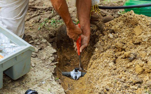 Sprinkler Repair — Man Working With Pipes Underground in Twin Falls, ID Sprinkler Repair — Man Working With Pipes Underground in Twin Falls, ID