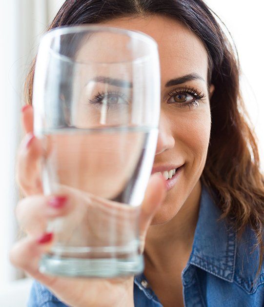Woman Holding A Glass Of Water At Home — Fort Lupton, CO — Glover's Drilling Woman Holding A Glass Of Water At Home — Fort Lupton, CO — Glover's Drilling