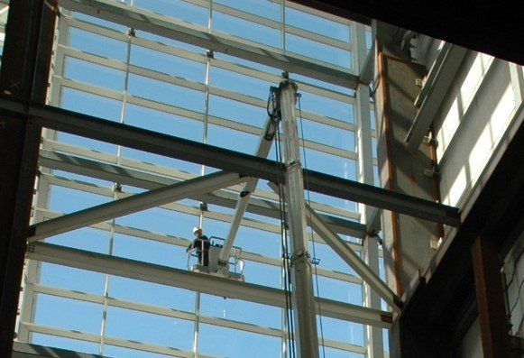 A man in a bucket is looking up at the ceiling of a building