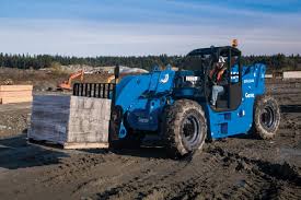 A blue forklift is carrying a pallet of bricks on a dirt road.