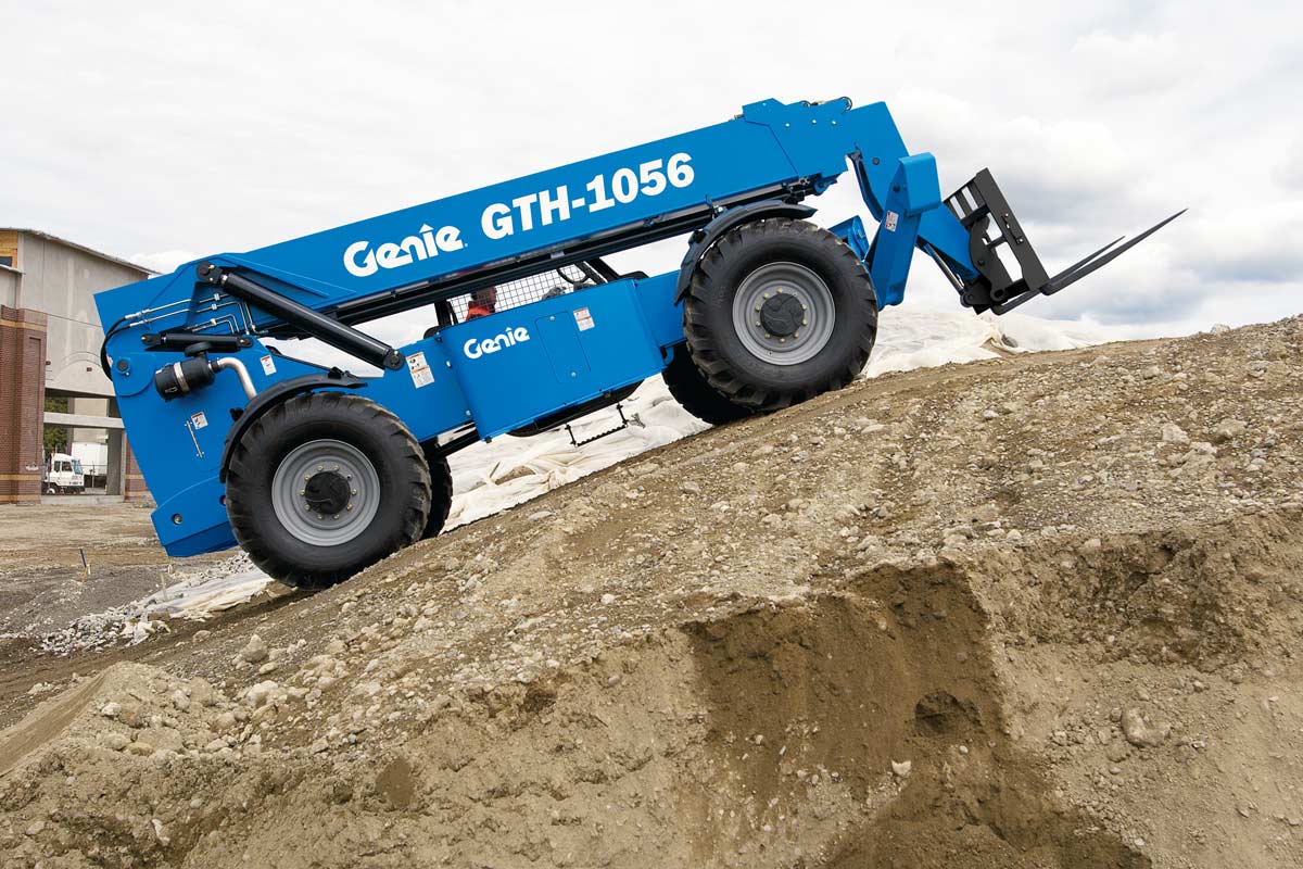 A genie gth-1056 forklift is driving down a dirt hill.