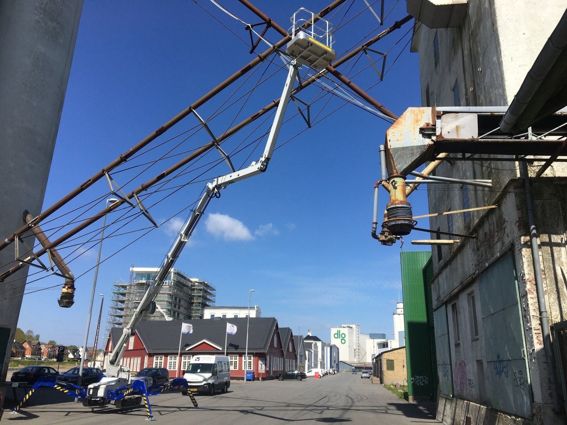 A crane with a ladder on top of it is in the middle of a street