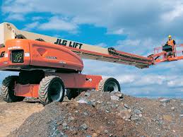 A jlg lift is sitting on top of a pile of dirt.