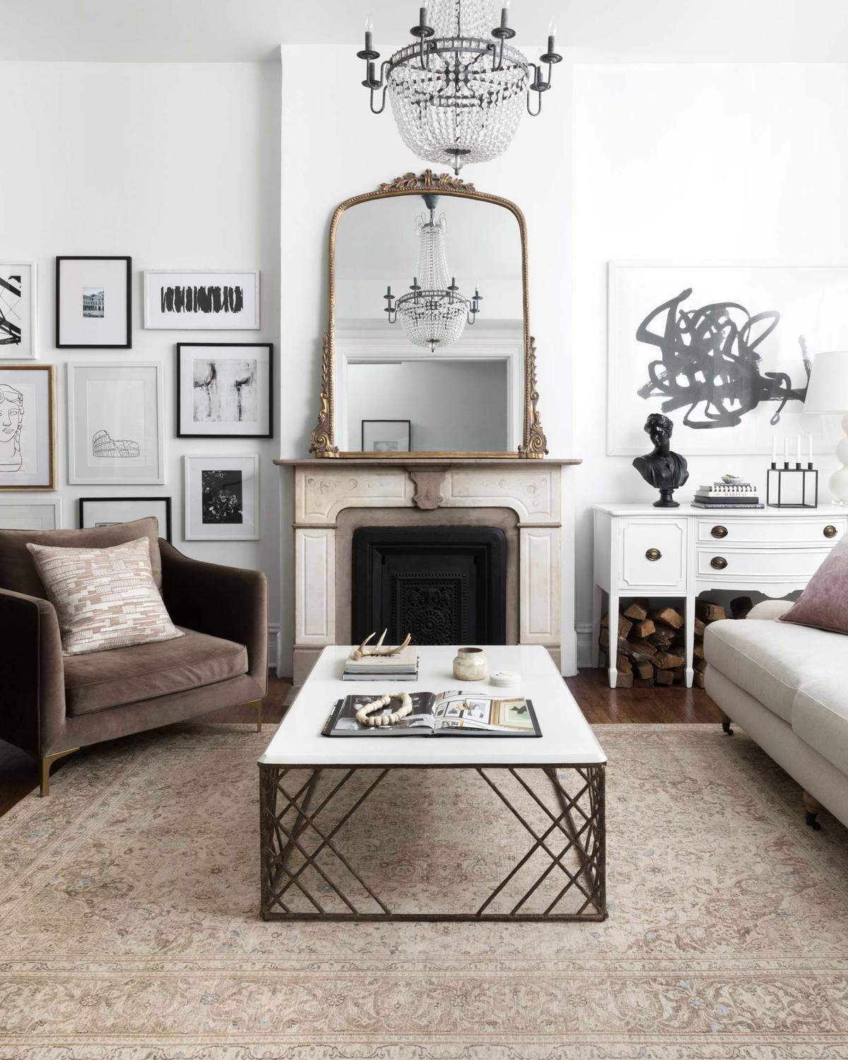 Stylish living room with fireplace, mirrored mantel, white sofa, brown chair, and coffee table on a shag rug