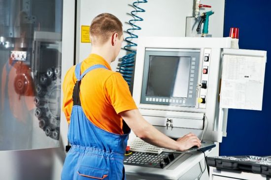 un ragazzo davanti a una postazione di controllo di un macchinario