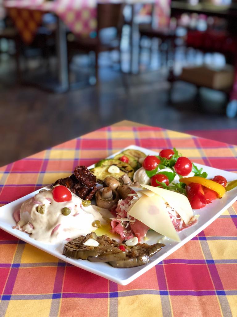 Auf einem Tisch steht auf einer karierten Tischdecke ein Teller mit Essen.