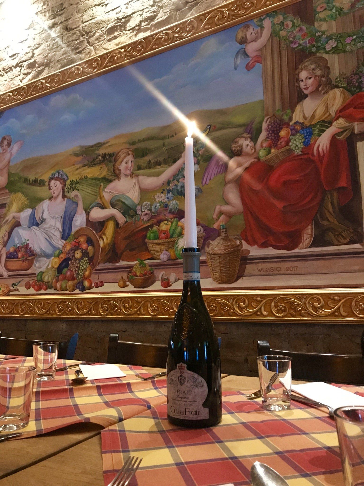 Eine Flasche Wein steht auf einem Tisch vor einem Gemälde.