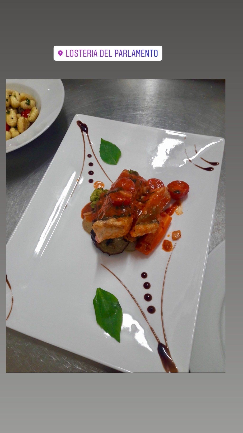 Ein weißer Teller mit Fleisch und Gemüse auf einem Tisch.