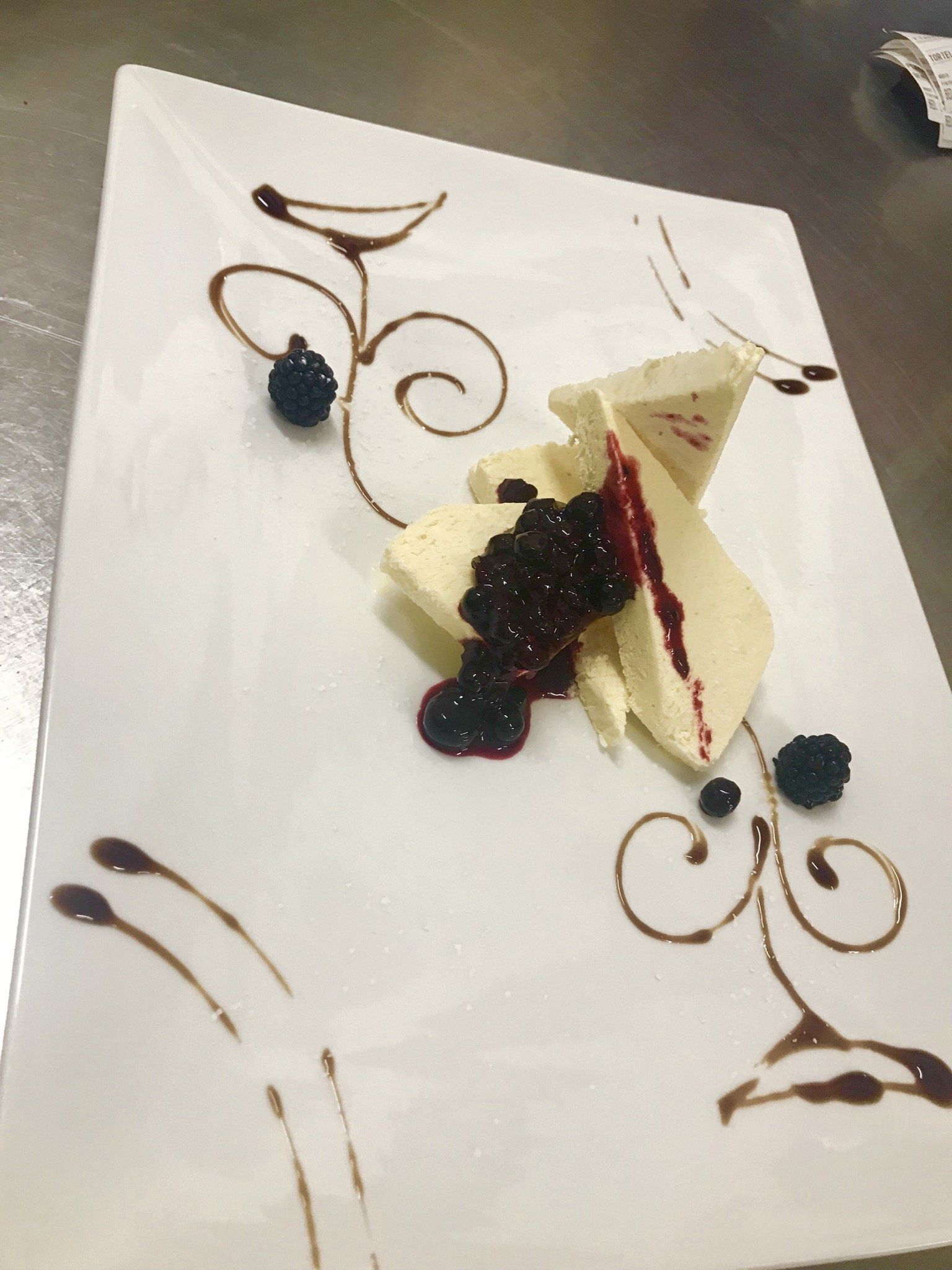 Ein weißer Teller mit einem Stück Käse und Beeren