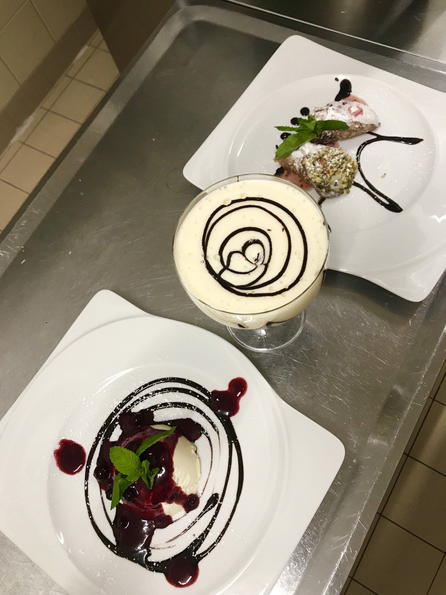 Drei Teller mit Desserts auf einer Arbeitsplatte aus Edelstahl