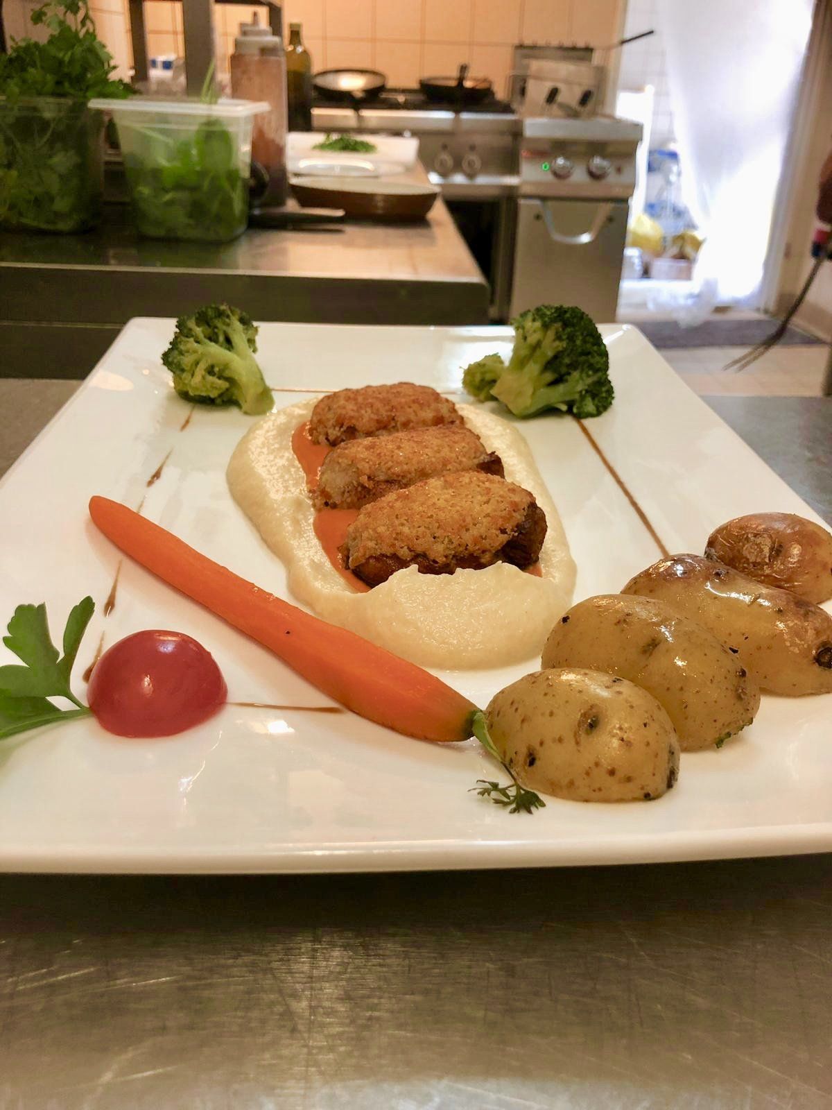 Ein Teller mit Essen mit Karotten, Brokkoli und Kartoffeln darauf