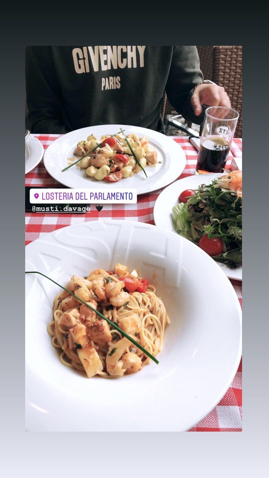 Eine Person sitzt an einem Tisch, auf dem Teller mit Essen stehen.