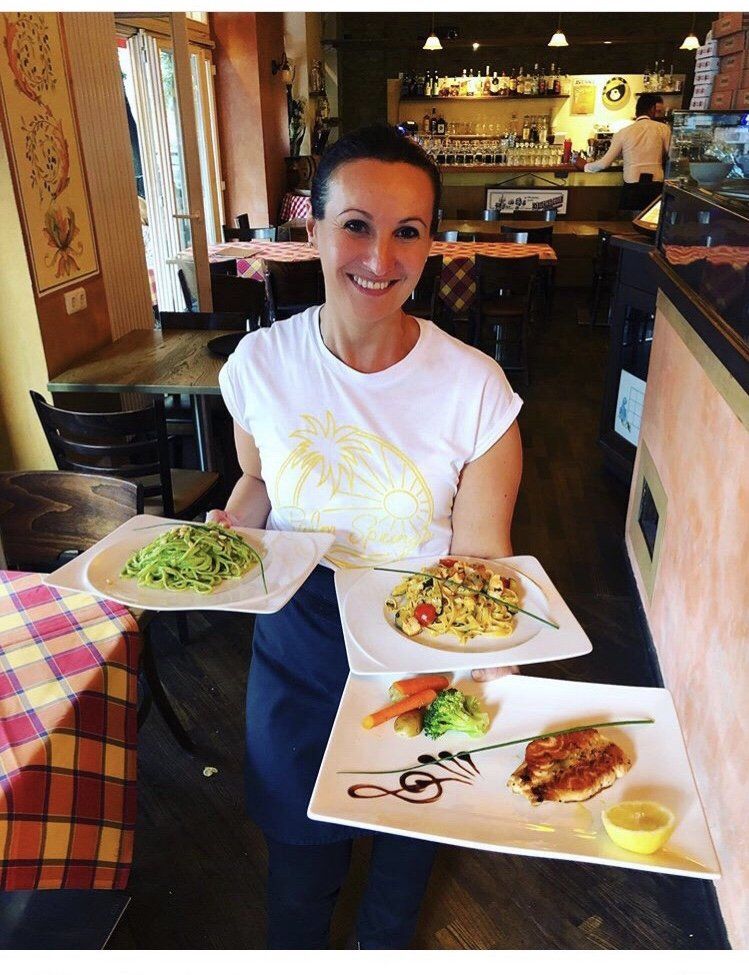 Eine Frau hält Teller mit Essen in einem Restaurant