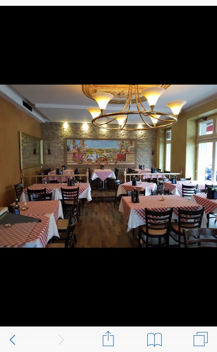 Ein Restaurant voller Tische und Stühle und einem Kronleuchter.